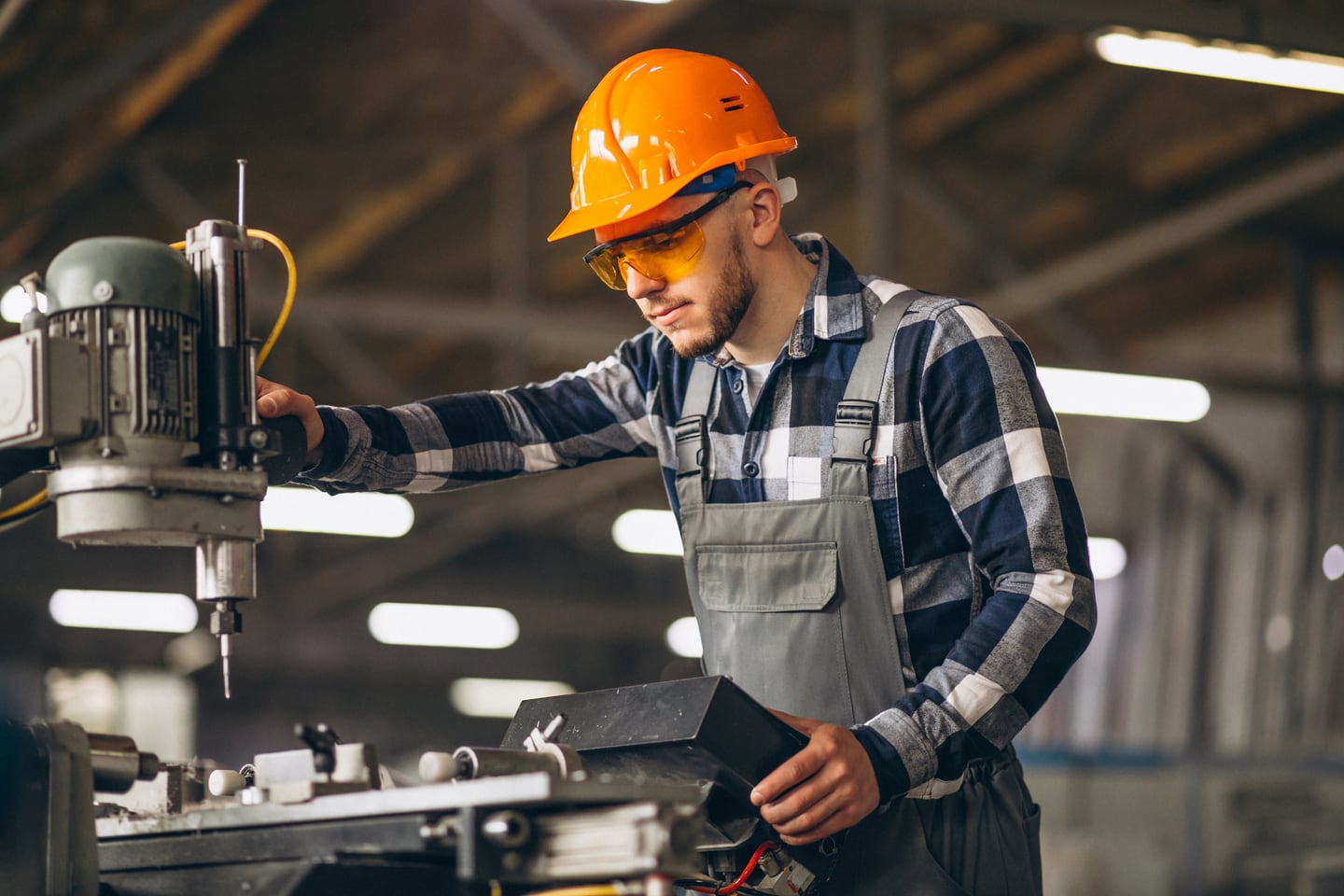 A worker in a hard hat operating machinery in Edinburg